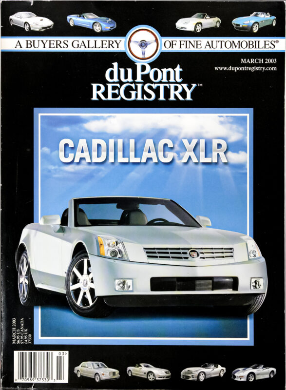 Magazine cover featuring a white Cadillac XLR convertible on display, with "duPont REGISTRY," "Cover Cars," and "March 2003" text at the top. Smaller images of various cars appear along the borders, celebrating the 40th Anniversary.