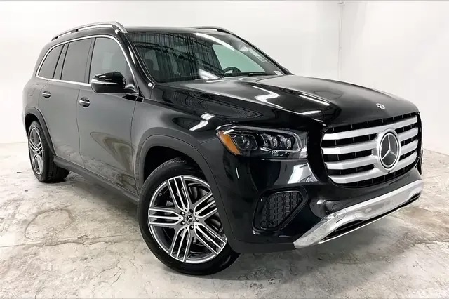 A black Mercedes-Benz SUV is parked in a white indoor studio with visible front grille, headlights, and alloy wheels—showcasing an excellent choice for those seeking the best car lease deals.