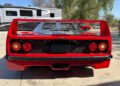Rear view of a red Ferrari F40 parked on concrete, with an RV and another red car in the background—an iconic moment perfect for collectors looking to buy now or bid at auction.