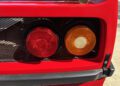 Close-up of the rear taillights and grille on a Ferrari F40 sports car, with one red and one amber light visible—an iconic detail for those looking to buy now or bid at auction.
