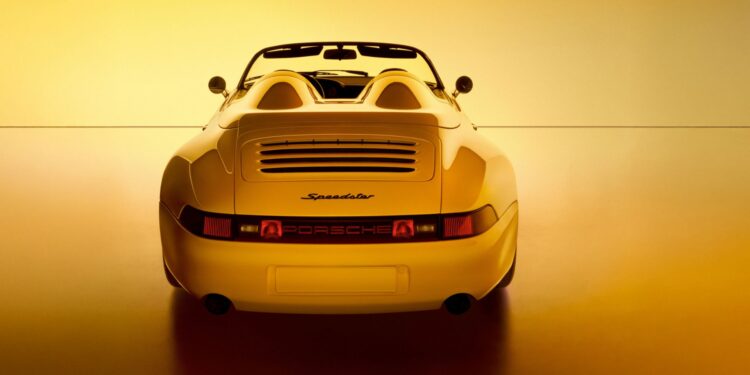 Rear view of a yellow Porsche Speedster convertible, a stunning example of Porsche exclusive craftsmanship, photographed against a warm yellow background.