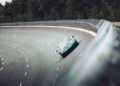 A Rimac Nevera, the fastest EV that breaks records, drives on a steeply banked race track, surrounded by trees and metal fencing.