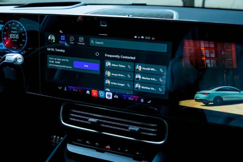 Car dashboard with a digital display showing a calendar event, communication apps, and a contact list; part of the speedometer and navigation map visible as Mercedes Benz becomes first automaker to natively integrate Microsoft Teams 365 Copilot.