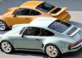 A light blue and a yellow classic sports car, part of a California-Based Singer’s latest reimagined Porsche 911 Carrera Coupes, are parked side by side on a concrete surface, viewed from above at an angle.