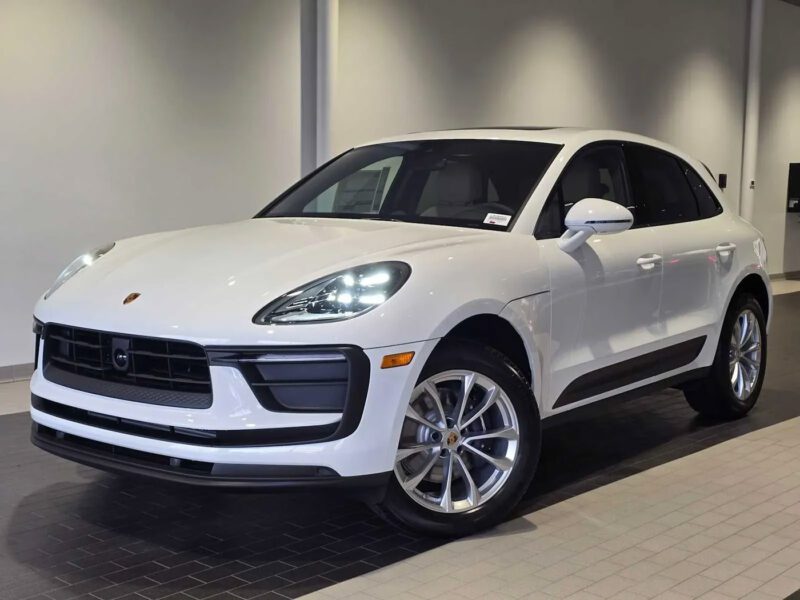 A white Porsche Macan SUV is parked indoors on a tiled floor under bright lighting—an inspiring sight for those seeking the best car leases or exceptional car lease deals.