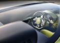 View of a luxury car's interior through the windshield, showcasing the Bugatti One-Off Brouillard's steering wheel with its iconic logo and advanced dashboard controls, all powered by the legendary W16 engine.