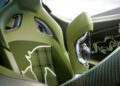 Close-up of a car’s green interior showing a plaid seat with a bull outline and gear selector featuring a bull emblem, with carbon fiber and metallic details reminiscent of Bugatti W16 sophistication in the Brouillard color scheme.
