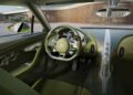 Interior view of the One-Off Brouillard Bugatti, featuring green leather seats, a Bugatti-branded steering wheel, W16-badging, and modern dashboard controls.
