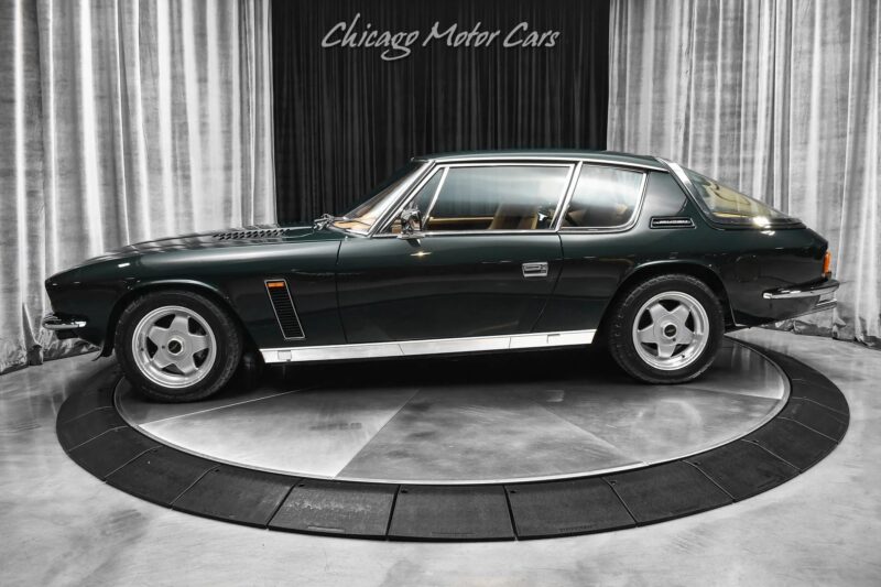 A classic dark green two-door coupe, steeped in nostalgia and history, is displayed on a rotating platform with "Chicago Motor Cars" written above.