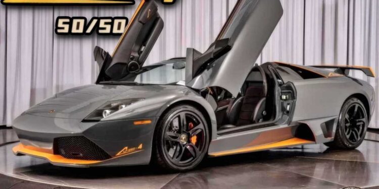 A grey Lamborghini Murciélago LP 650-4 with its scissor doors open sits on a turntable, showcasing orange accents and #50-of-50: LAST Lamborghini Murciélago LP 650-4 Roadster for Sale at Prestige Imports special edition branding.