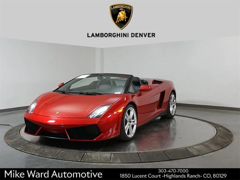 A red Lamborghini convertible V10 supercar is displayed in a showroom with Lamborghini Denver branding and dealer contact information visible, highlighting that select Lamborghini Gallardos are also for sale.