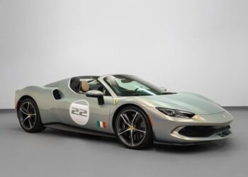 A silver Ferrari convertible sports car in classic Ferrari colors, with the number 22 on the door and an Italian flag decal, is parked indoors on a gray floor.