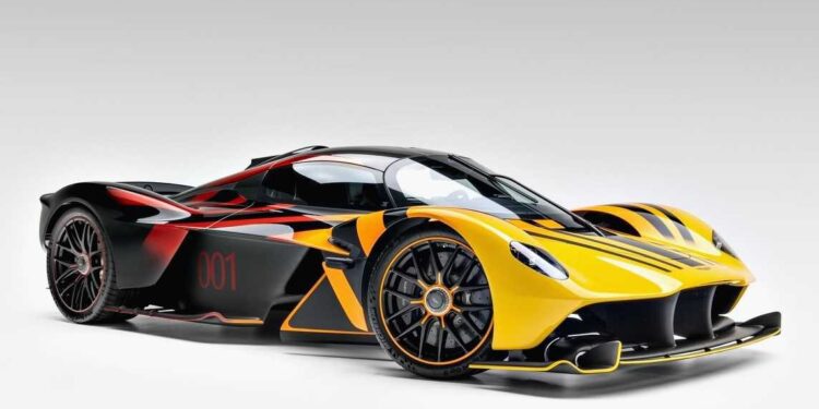 A yellow and black Aston Martin Valkyrie with red accents and the number 001 on its side, photographed on a plain white background, is now for sale at O’Gara Coach.