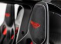 Close-up of a car seat headrest with a red embroidered Aston Martin logo and black carbon fiber interior details in the ultra-rare Aston Martin Valkyrie, now for sale.