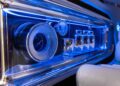 Close-up of the Mercedes-Benz Vision V concept van luxury glassware compartment, featuring illuminated speakers, glasses, and a blue LED light.