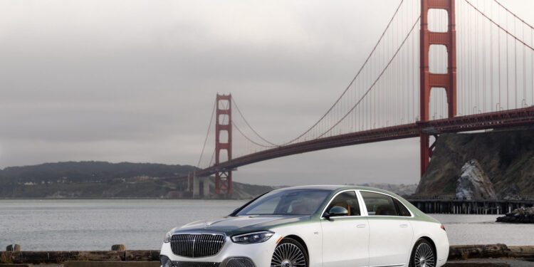 A white Mercedes-Maybach S 680 luxury sedan is parked near the water with the Golden Gate Bridge in the background on a cloudy day, highlighting this limited edition model’s elegance.
