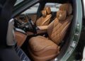 Luxurious car interior with brown quilted leather seats, a sleek dashboard, and a waterfront view through the window—this is the limited edition Mercedes-Maybach S 680, redefining comfort like an escape to the Emerald Isle.