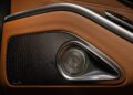 Close-up of a limited edition Mercedes-Maybach S 680 door panel, showcasing brown leather, patterned stitching, and a metallic speaker grille with a circular design.
