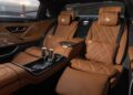 Luxurious tan leather rear seats of the limited edition Mercedes-Maybach S 680 feature quilted stitching, leg rests, two cup holders with glasses, and the Golden Gate Bridge visible through the window.