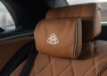 Close-up of a brown leather car seat with diamond stitching in the limited edition Mercedes-Maybach S 680, featuring a headrest pillow adorned with the Maybach logo.