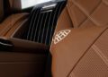 Close-up of brown leather car seats with perforated and quilted patterns, featuring a white Maybach logo and glossy black center panel in the limited edition Mercedes-Maybach S 680 Emerald Isle.