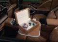 A luxury Mercedes-Maybach S 680 interior with tan leather seats features an open box labeled "Edition Emerald Isle," containing two watch-like objects and a colorful small case on a fold-out tray, highlighting this limited edition experience.