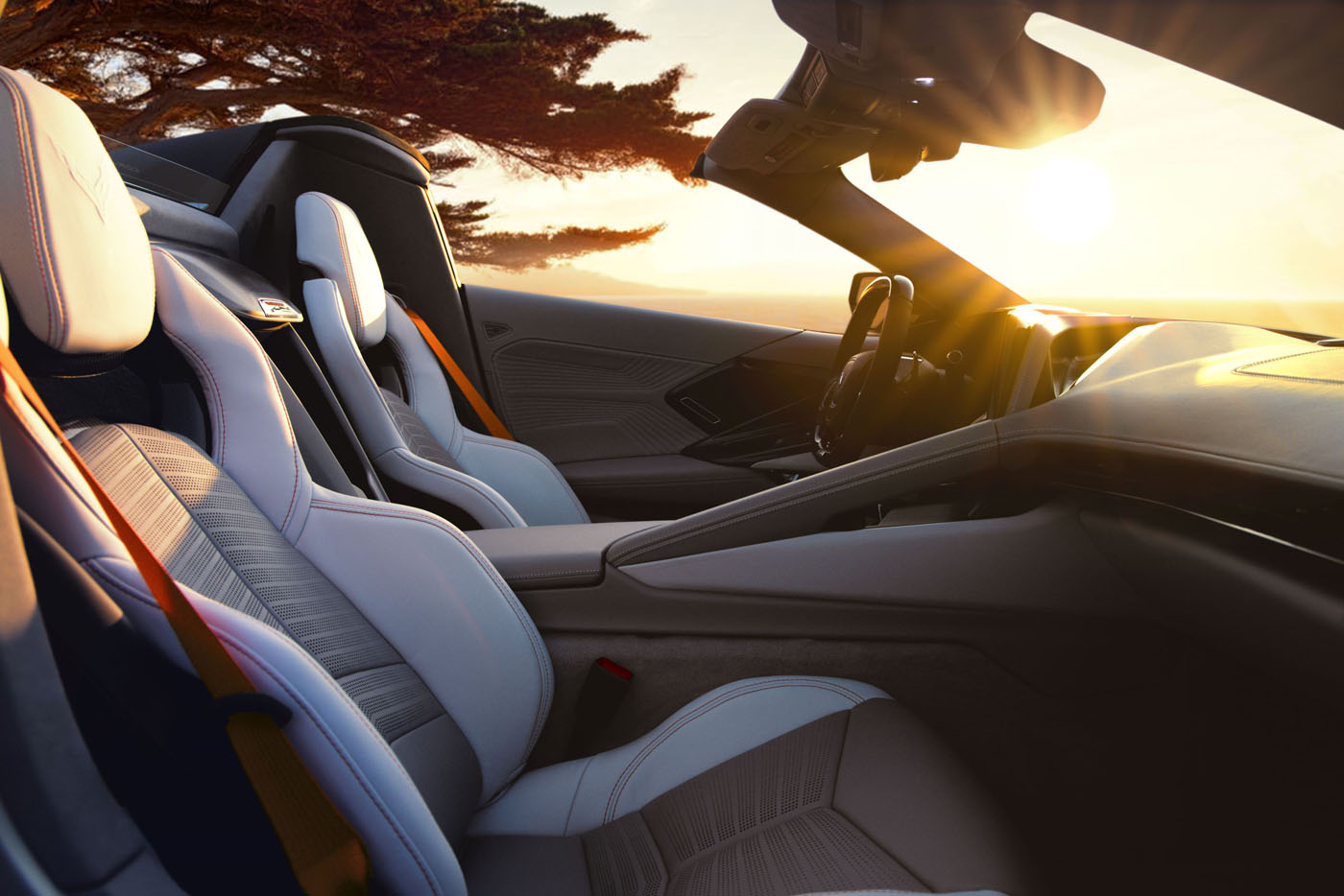 Sunlight streams over the sleek, modern interior of a Corvette ZR1X, highlighting light-colored seats and dashboard in this stunning Quail Silver Limited Edition unveiled at Monterey Car Week.