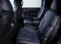 The image shows the interior of a vehicle with two rows of blue leather seats, armrests, and visible cup holders—highlighting the 2026 INFINITI QX80 SPORT Grade, which truly ups the luxury game.