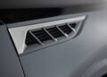 Close-up of a car’s side vent with a chrome and black finish, showing angled slats and part of the matte gray body panel—highlighting how the 2026 INFINITI QX80 Introduces SPORT Grade Ups the Luxury Game.