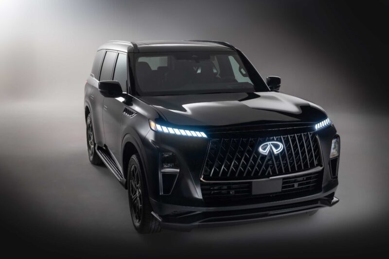 A black 2026 INFINITI QX80 with a large front grille and distinctive LED headlights is parked in a studio with a neutral background, as the new SPORT Grade ups the luxury game.