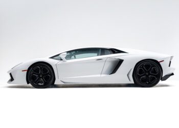 A white Lamborghini Aventador sports car in a side profile view against a plain white background.
