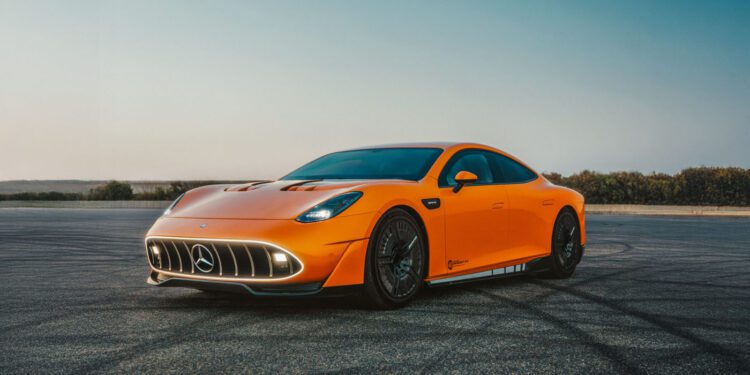 An orange CONCEPT AMG GT XX Mercedes-Benz sports car is parked on an empty, sunlit asphalt surface with clear skies, ready for an exhilarating drive around the world.