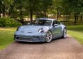 A blue sports car, reminiscent of the million-dollar cars at Mecum’s Monterey 2025 Auction, is parked on a driveway.