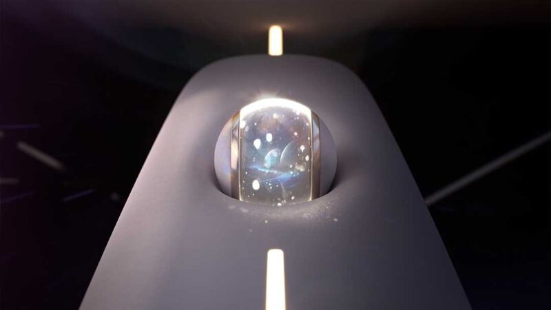 A glass dome with glowing particles inside sits on a sleek, dark surface under a strip of light—evoking the Buick Electra Orbit Concept, where '50s Jet Age meets modern minimalism.