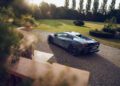 A silver Lamborghini Bespoke Temerario is parked on a gravel driveway next to a curved staircase, with a lawn and tall trees in the background—capturing the elegance of Porto Cervo.