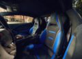 Interior view of a luxury Lamborghini showcasing two black and blue Bespoke Temerario sports seats, each adorned with the iconic logo on the headrests, inspired by Porto Cervo elegance.