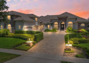 A luxury custom estate in Keene's Pointe, Windermere Florida, featuring a spacious house with a grand driveway.