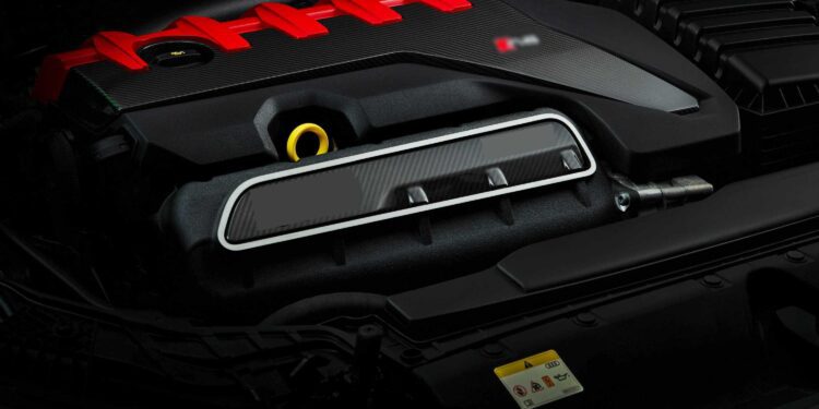 Close-up view of a modern car engine with a red engine cover, black components, and visible warning label—The Last Surviving 5-Cylinder On Sale Today Packs A Punch under the hood.