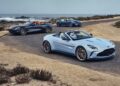 Three convertible sports cars from the Thrillseeker Collection drive along a coastal road, with the ocean and rocky shoreline in the background.