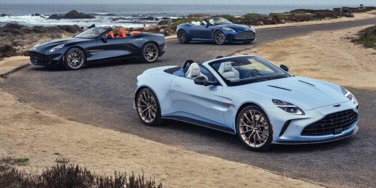 Three convertible sports cars from the Thrillseeker Collection drive along a coastal road, with the ocean and rocky shoreline in the background.