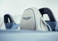 Close-up of a white car seat with the Aston Martin logo embroidered on the headrest, inside a convertible vehicle, celebrating Aston Martin Marks 75 Years in the Americas With Thrillseeker Collection and Valhalla Debut at Monterey.