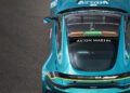Overhead view of a teal Aston Martin Vantage S on asphalt, displaying branding and sponsor logos on the rear and roof—reminiscent of a sleek Formula 1 Safety Car.