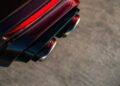 Close-up of a BRABUS Rocket GTC Deep Red’s dual exhaust pipes and rear bumper, highlighting the red taillight detail on a paved surface. Breaks cover at Pebble Beach with 1000 HP and an all-carbon body.
