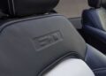 Close-up of a car seat with black leather upholstery, white stitching, and an embossed logo on the upper backrest in the Bronco Turns 60: Ford Reveals Heritage Edition for 2026.
