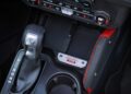 Close-up of a car’s center console showing a gear shifter, cup holder, climate controls, and a badge labeled “Bronco Raptor 60,” celebrating Bronco Turns 60: Ford Reveals Heritage Edition for 2026.