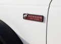 Close-up of a vehicle’s side badge showing the word "Bronco," a running horse logo, and "EST. 1966" on a white background near the wheel arch as Bronco Turns 60: Ford Reveals Heritage Edition for 2026.