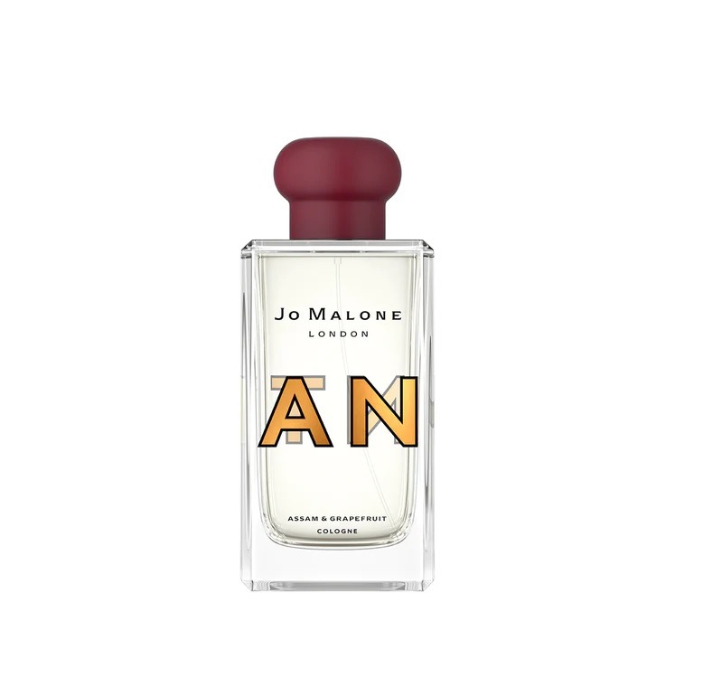 A clear glass bottle of Jo Malone London cologne with a red cap and the text "AN" in bold letters over the label, perfect for adding style to your collection of luxury accessories.