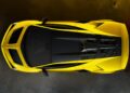 A yellow Lamborghini Fenomeno: Limited-Run V12 Masterpiece, viewed from above, showcases its aerodynamic design and black roof detailing as it sits on a textured concrete surface.