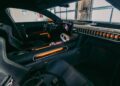 Interior view of a modern Mercedes-AMG GT sports car featuring black leather seats, orange accents, a digital dashboard, and sleek controls—echoing the high-performance spirit seen at Nardò during its 24-Hour Distance World Record run.