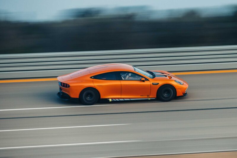 A Mercedes-AMG GT speeds along a multi-lane highway with a blurred background, reminiscent of its performance at Nardò during the 24-Hour Distance World Record attempt.